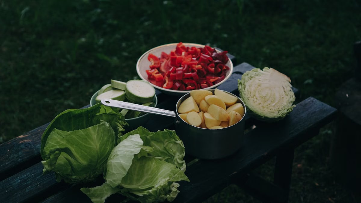 Freshly chopped vegetables on an outdoor table, perfect for a healthy meal.